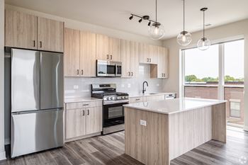 A modern kitchen with wooden cabinets and stainless steel appliances.